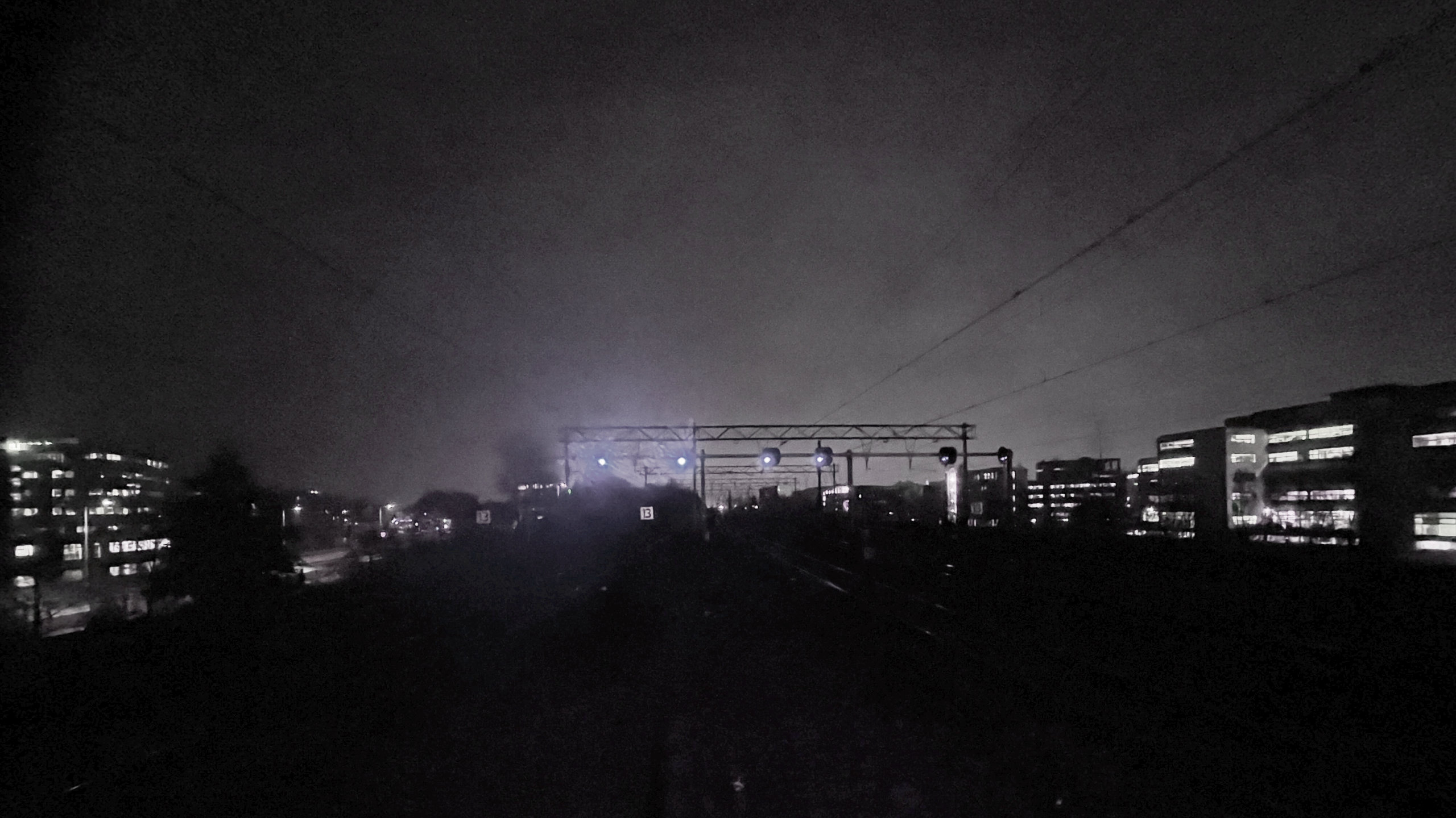 View over a railway in a small city, during a rainy, dark evening